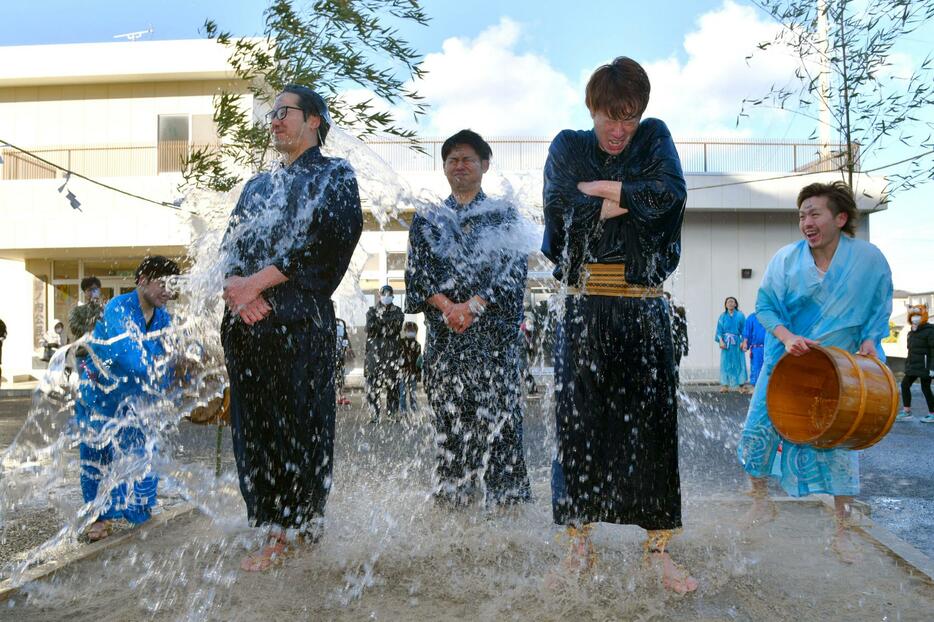 奇祭「水祝儀」で冷水を浴びせられる大和田裕貴さん（左）ら3人の花婿＝8日午後、福島県いわき市