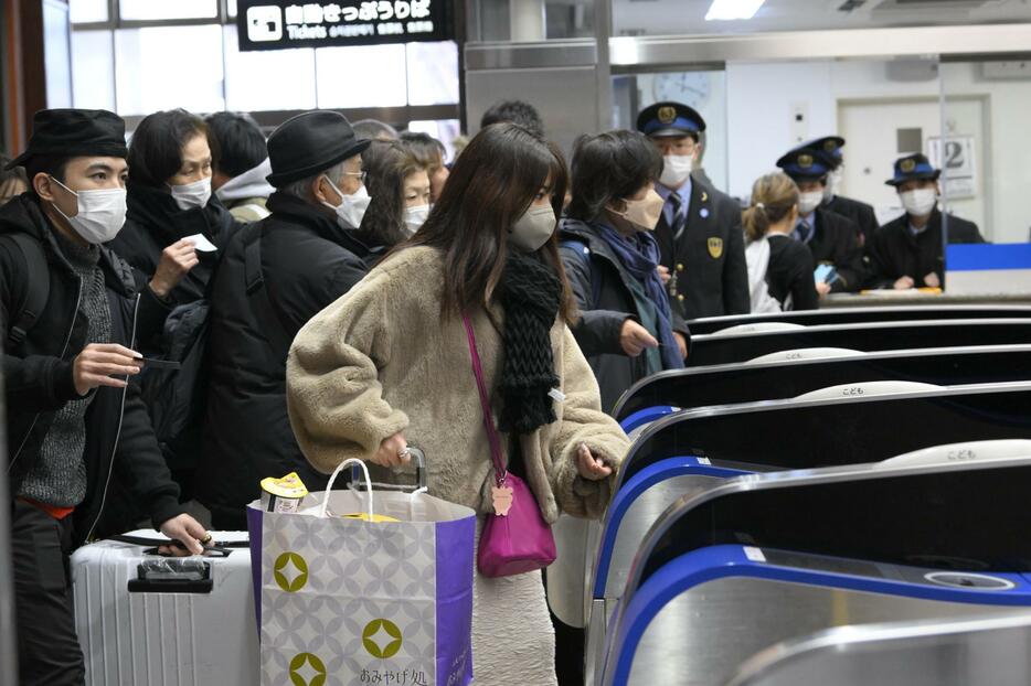 JR金沢駅で北陸新幹線の東京行き列車の運転再開予定がアナウンスされ、改札を通る乗客ら＝2日午後0時19分