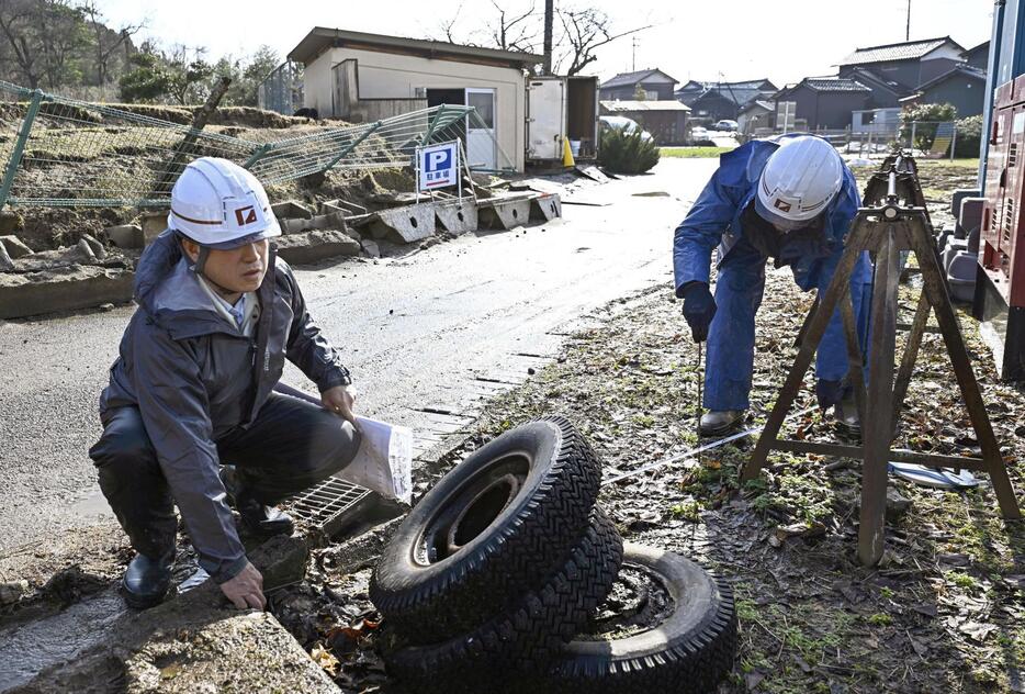 仮設住宅が建設される石川県珠洲市立正院小で行われた測量作業＝12日午前