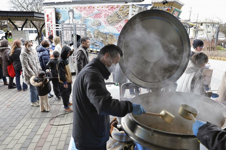 石川県志賀町立志賀小で、炊き出しに並ぶ人たち＝7日午後0時55分