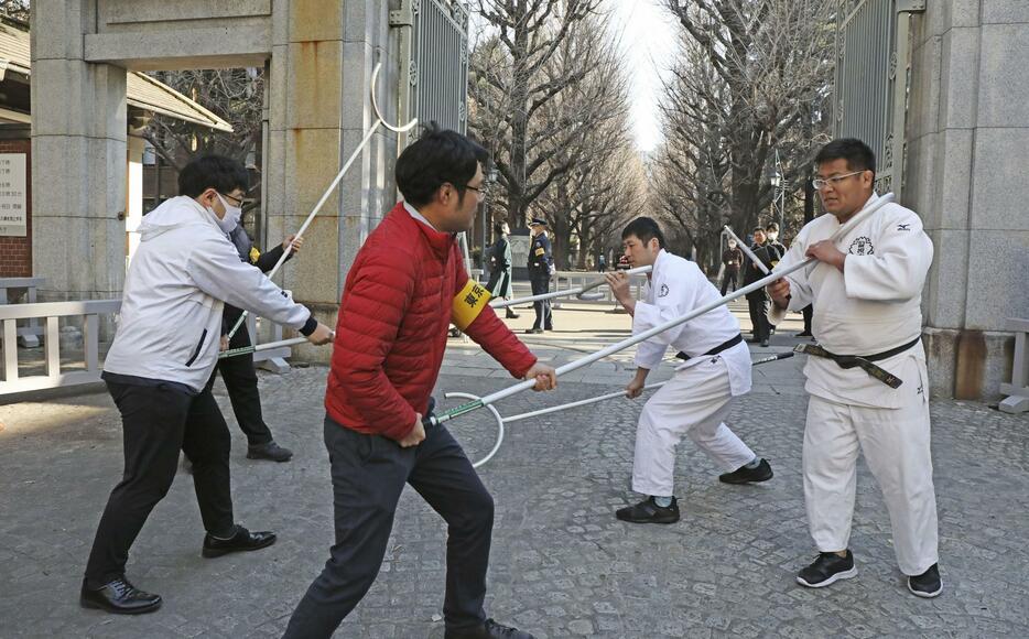 道着姿の警視庁本富士署員から刺股の使用方法を学ぶ東大職員＝10日午前、東京都文京区の東大前