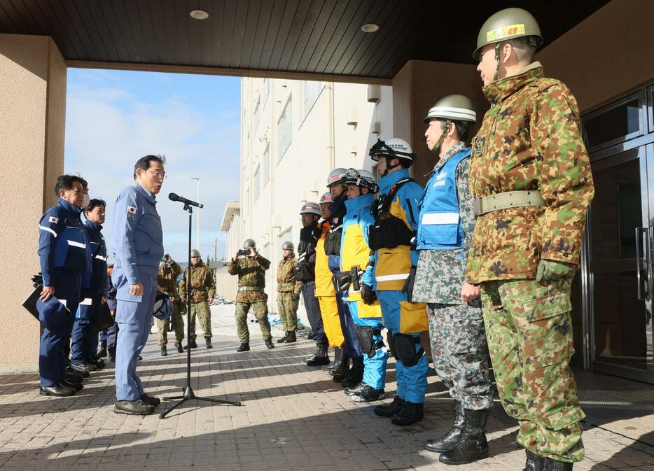 被災地視察のため航空自衛隊輪島分屯基地に到着し、自衛隊員らを激励する岸田首相（左手前）＝14日午前、石川県輪島市（代表撮影）