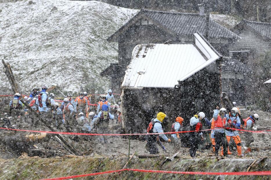 能登半島地震で大きな被害を受けた石川県輪島市市ノ瀬町で、安否不明者を捜索する消防隊員ら＝23日午前