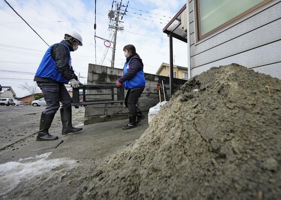 家屋から家具を運び出すボランティア＝27日午前、石川県七尾市