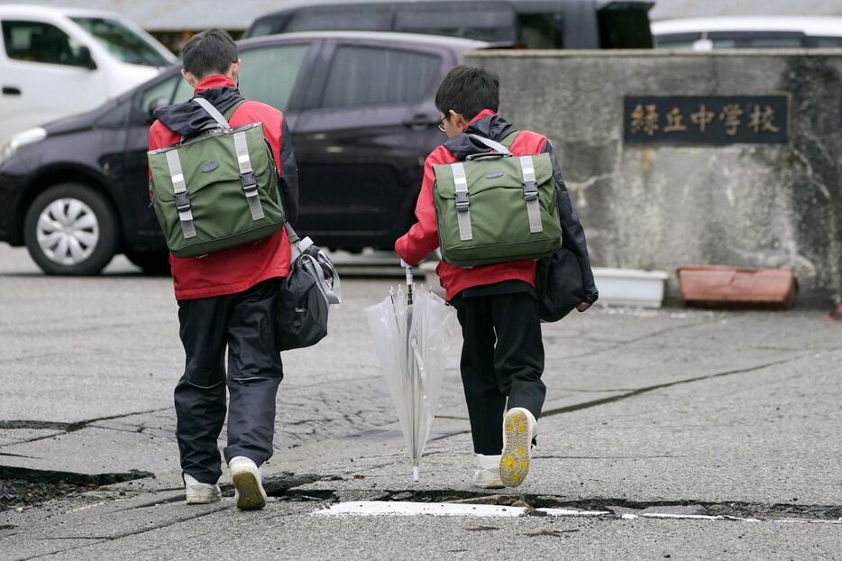 通常授業が再開され、登校する珠洲市立緑丘中の生徒たち＝22日午前、石川県珠洲市