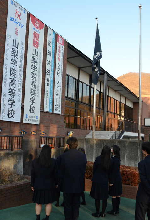 センバツ出場を祝って掲げられた懸垂幕（左端）＝甲府市酒折３の山梨学院高で