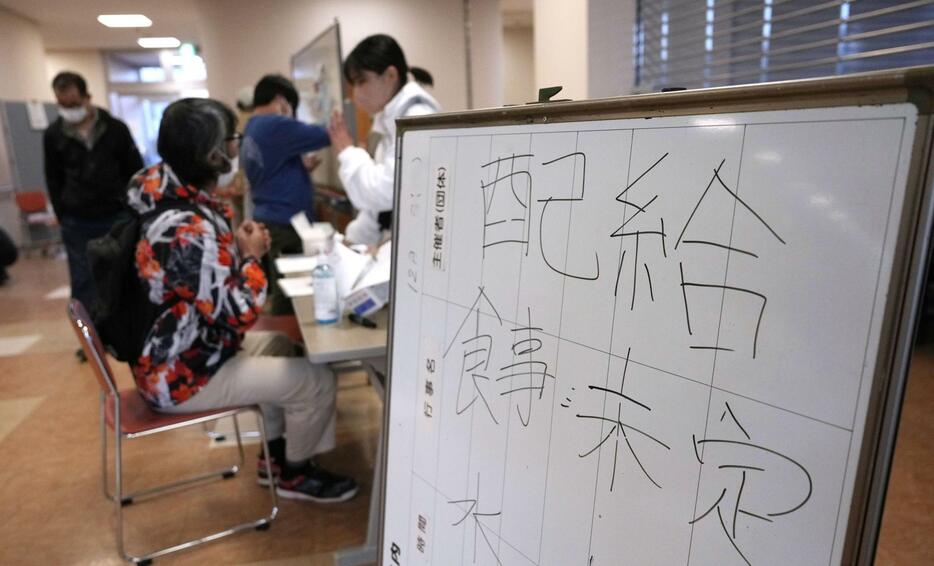 食事や水の配給が未定であることを知らせる避難所の掲示板＝2日、石川県輪島市