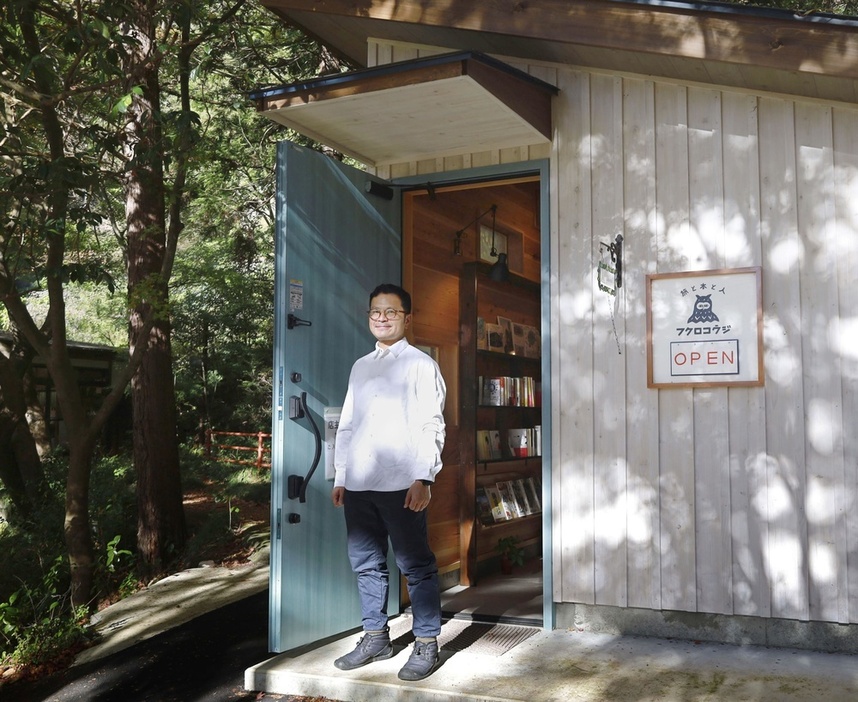 撮影に応じる旅行代理店「フクロコウジ」の店主、原沢香司（はらさわ・こうじ）さん。店舗では旅をテーマにした本も販売している＝2023年11月、群馬県中之条町