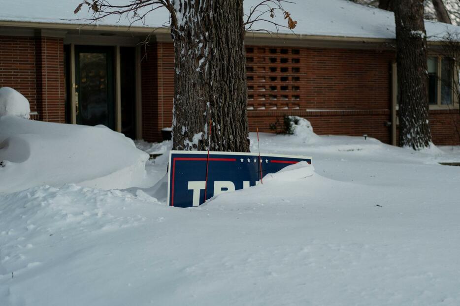 雪に埋もれたトランプ前米大統領支持の看板＝14日、アイオワ州（ロイター＝共同）