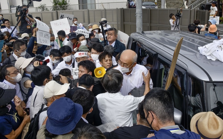 山口県上関町役場前で、使用済み核燃料の中間貯蔵施設建設に反対する人らに取り囲まれる西哲夫町長（中央右端）＝2023年8月18日