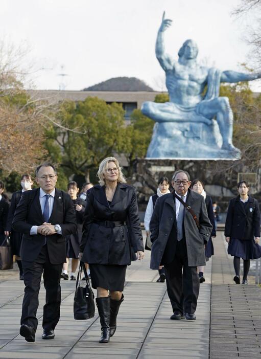 平和公園を歩くICANのメリッサ・パーク事務局長（左から2人目）。左端は川崎哲国際運営委員＝21日午前、長崎市