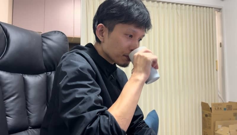 飲み物を飲む青木渉さん（家族提供、２０２３年１１月１４日自宅で撮影）