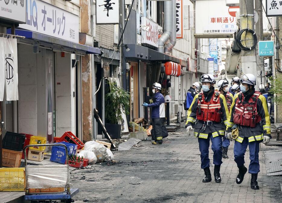 火災があった「鳥町食道街」周辺を調べる消防隊員ら＝5日正午ごろ、北九州市小倉北区