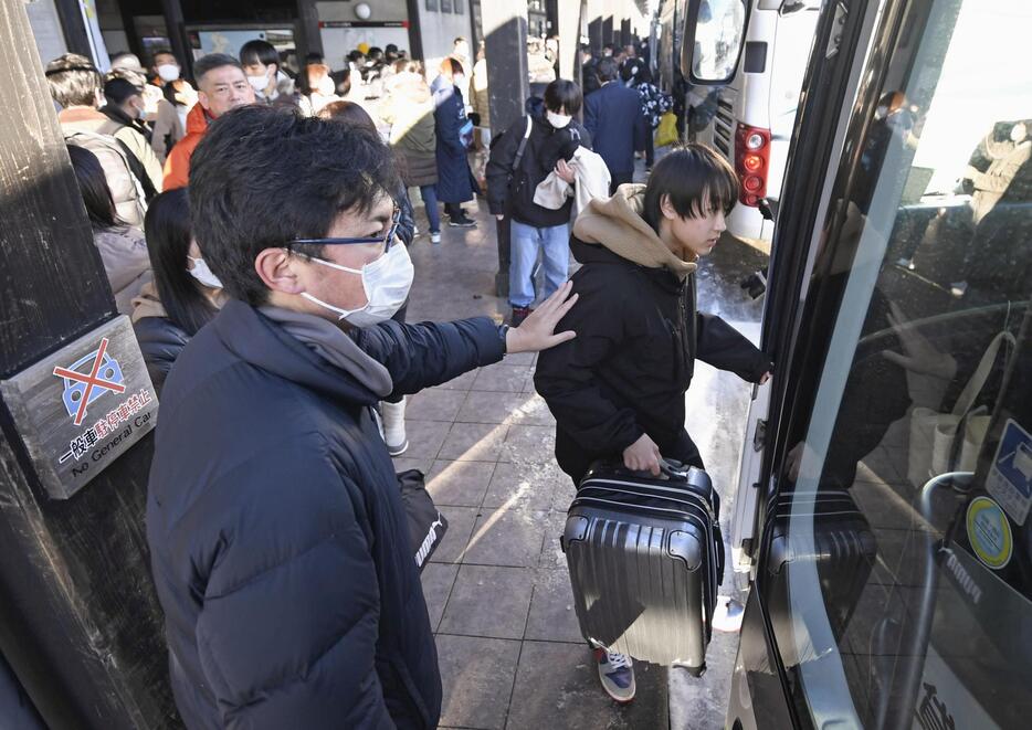 石川県白山市への集団避難で、バスに乗り込む中学生＝17日午前、石川県輪島市