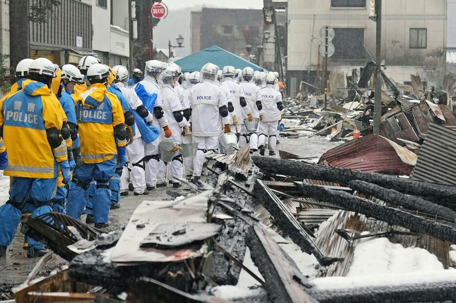 安否不明者捜索のため、石川県輪島市の「輪島朝市」付近に集まる大勢の警察官ら＝9日午後