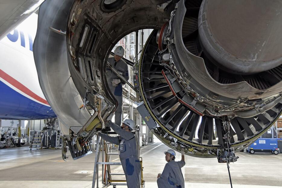 ジャンボ機・ボーイング747のエンジン部分で作業する整備士＝30日、成田空港