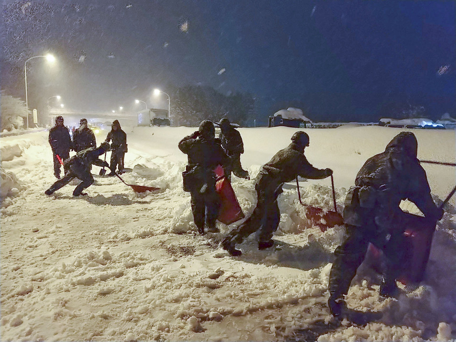 名神高速道路の関ケ原インターチェンジ付近で除雪作業をする自衛隊員ら＝24日午後（防衛省提供）