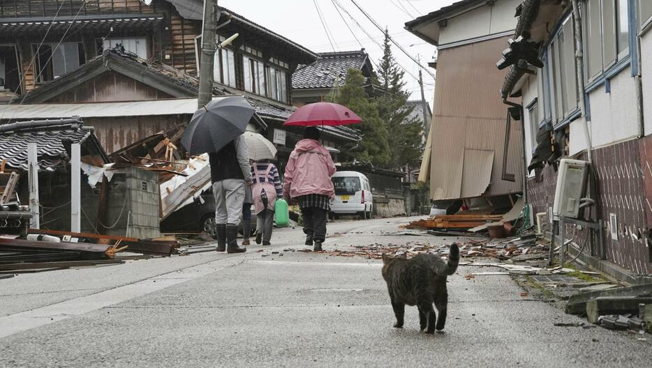 地震の被害を受けた石川県珠洲市を歩く人たち＝3日午後