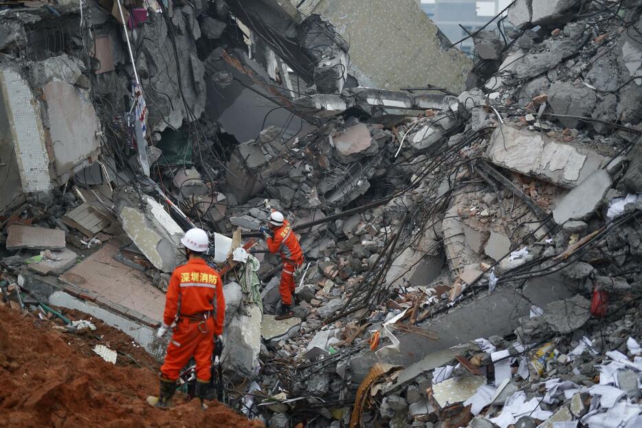 崩壊した建物の中で生存者の手がかりを探す救助隊員＝2015年12月20日（写真：ロイター/アフロ）