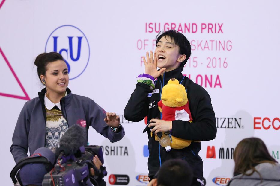 くまのぬいぐるみを小脇に喜ぶ羽生＝2015年12月12日（写真：YUTAKA/アフロスポーツ）