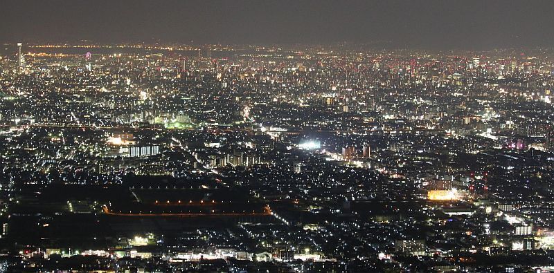 [写真]冬至の夜、気温4度台の生駒山から大阪の夜景を望む。左上端に「あべのハルカス」、右上端に梅田などの高層ビル群、手前の黒い部分は東大阪市池島町付近＝22日午後8時半ごろ、信貴生駒スカイライン・鐘の鳴る展望台で