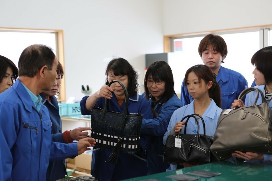 手編みのバッグを持つ「アストロ・テック」の女性従業員ら＝2013年1月（隼田正洋氏撮影）