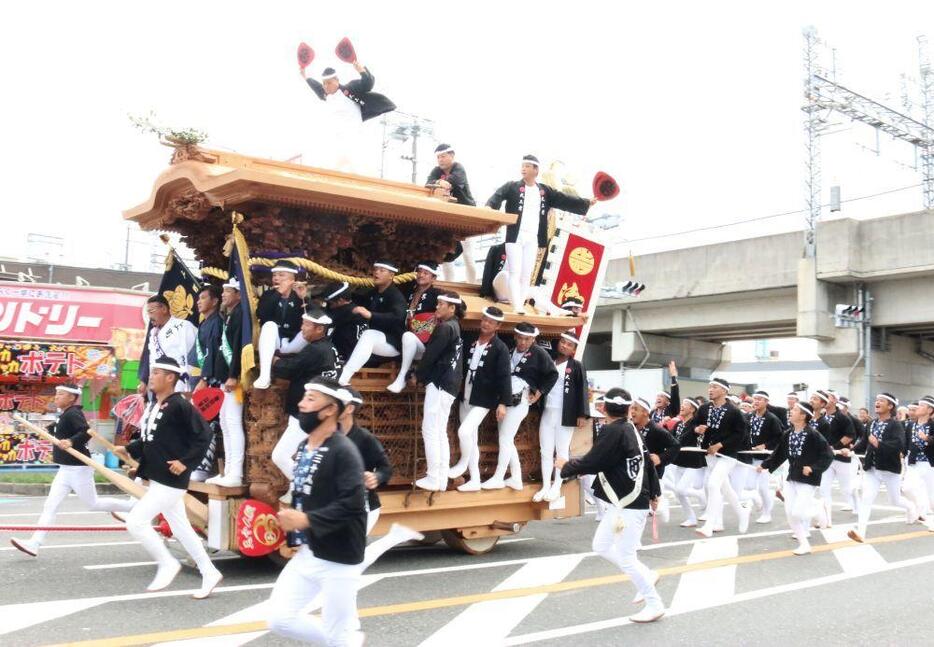 ［写真］「そーりゃ」のかけ声とともに、走り抜けるだんじり＝17日午前、大阪府岸和田市で