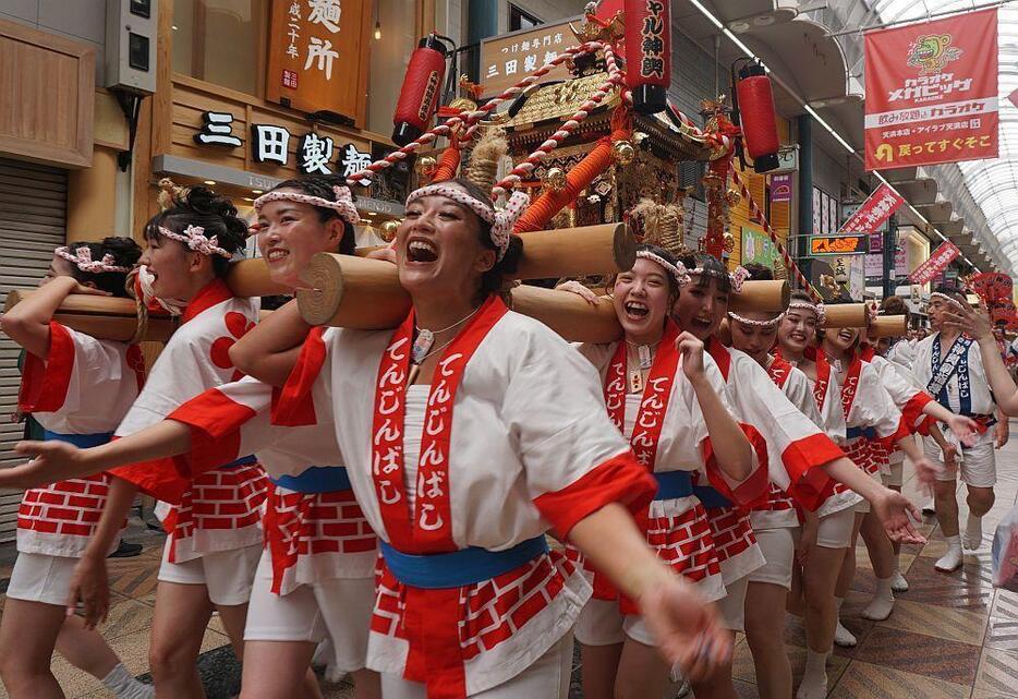 ［写真］わっしょいわしょいの掛け声とともに練り歩くギャルみこし＝23日午前11時40分ごろ、大阪市北区で