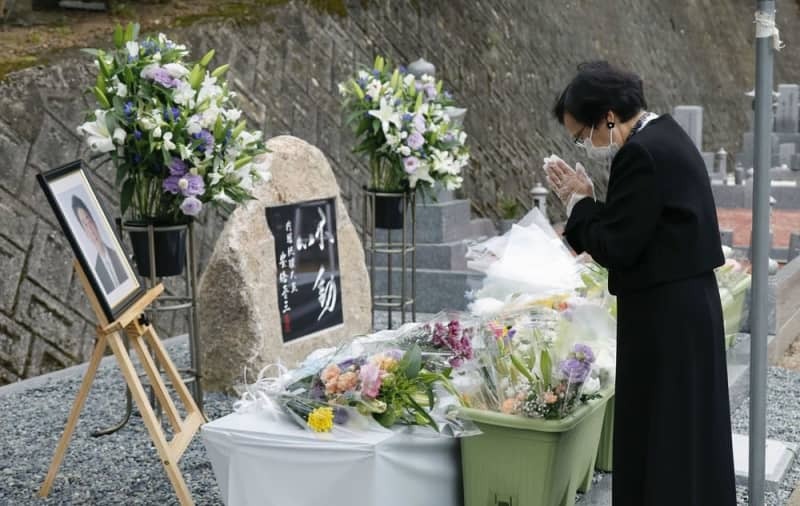 安倍元首相銃撃事件から１年となり、慰霊碑の前で手を合わせる人＝７月８日、奈良市