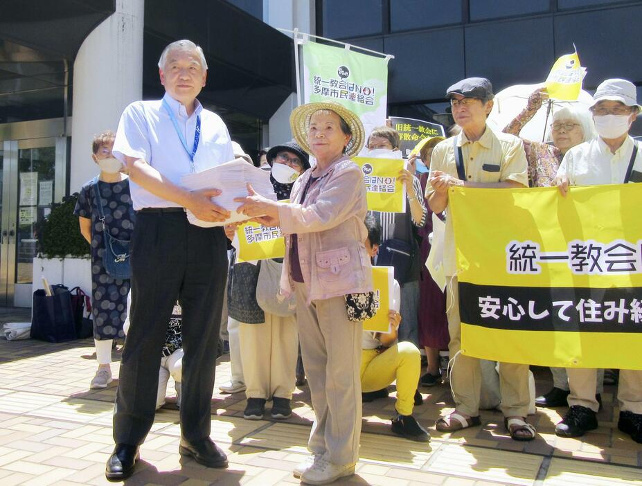 東京都多摩市の阿部裕行市長（左端）に署名を手渡す市民団体の佐久間む津美共同代表＝24日午後、多摩市
