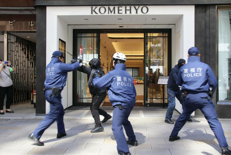 警視庁が実施した強盗対処訓練で、犯人役を制圧する警察官＝24日午前、東京・銀座