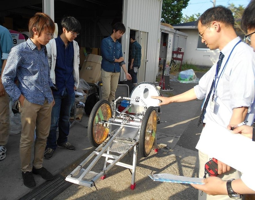 [写真]車体を検討する岡田教授（右）と学生たち