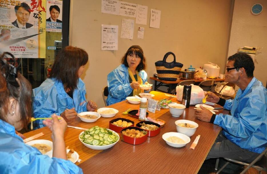 電話での呼びかけの合間に、持ち寄った料理を食べながら選挙戦について語る三反園氏の支援者たち。小川みさ子氏は写真中央（6月23日撮影：木野千尋）