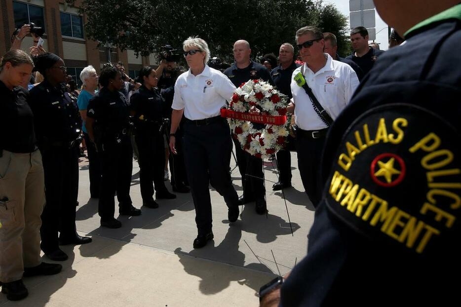 [写真]7月7日のダラスでの警官狙撃事件を受け、ダラスの警察本部に花輪が運ばれた（ロイター/アフロ）