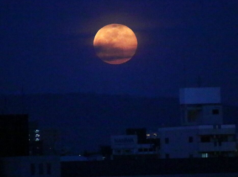 [写真]なにわの夜空は雲が多く、おぼろげな「ピンクムーン」となった＝27日午後7時10分ごろ、大阪市西成区で