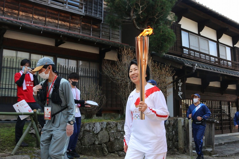 [写真]石畳の坂道をゆっくりした足取りで登る加藤智子さん（2021年4月3日午前9時ごろ）