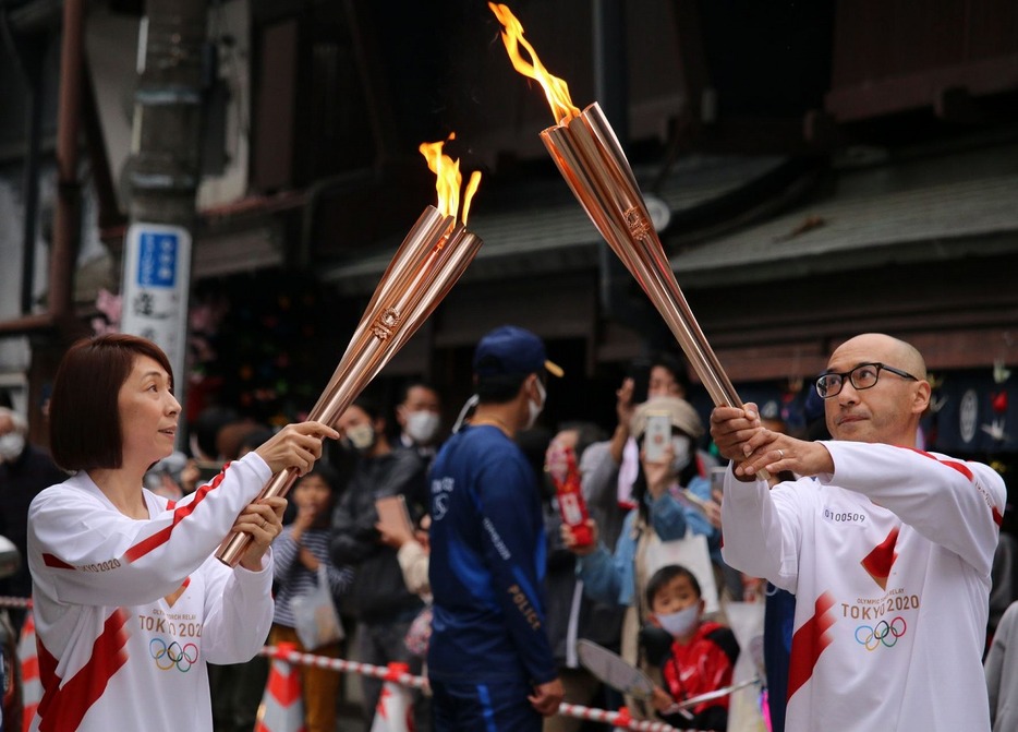 [写真] 岐阜県郡上市の聖火リレーで籏修子さん（左）から聖火を引き継ぐ渡辺一吉さん（2021年4月3日午後4時50分ごろ）