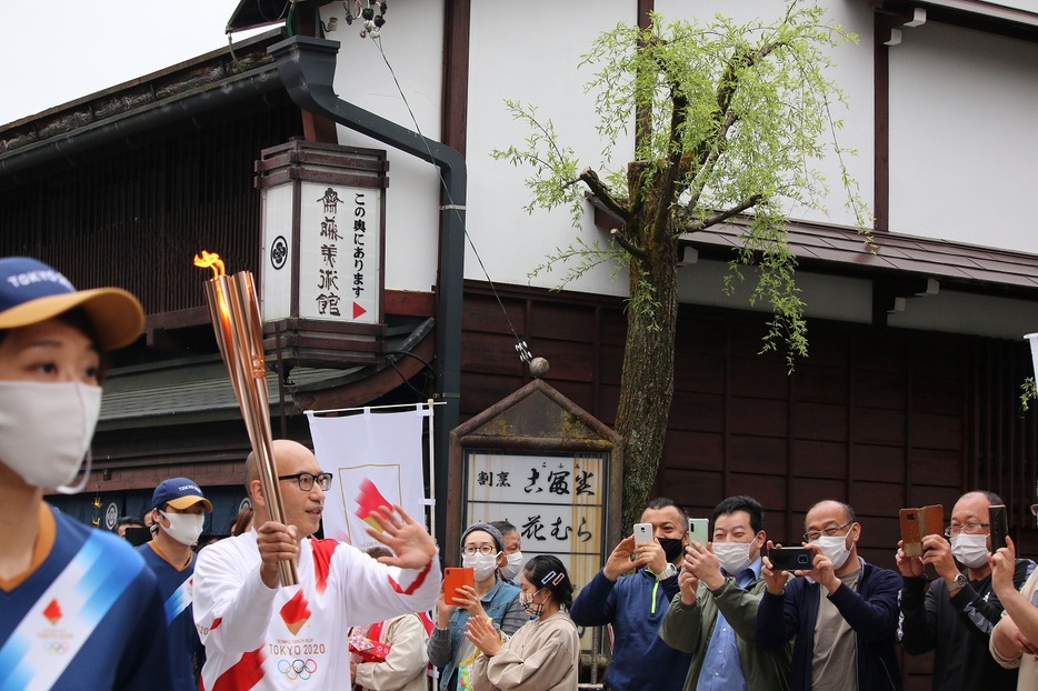 [写真]やなか水のこみち前の新町通りを走る渡辺一吉さん（2021年4月3日午後4時50分ごろ）