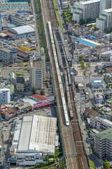 京都本線の大山崎駅から上牧駅付近にかけては東海道新幹線と並行する。写真は水無瀬駅上空で、河原町方面の列車と東京方面へと向かう東海道新幹線の700系が並走。そのあいだを対向の特急梅田行き9300系が通過する（2012年5月12日、吉永陽一撮影）。