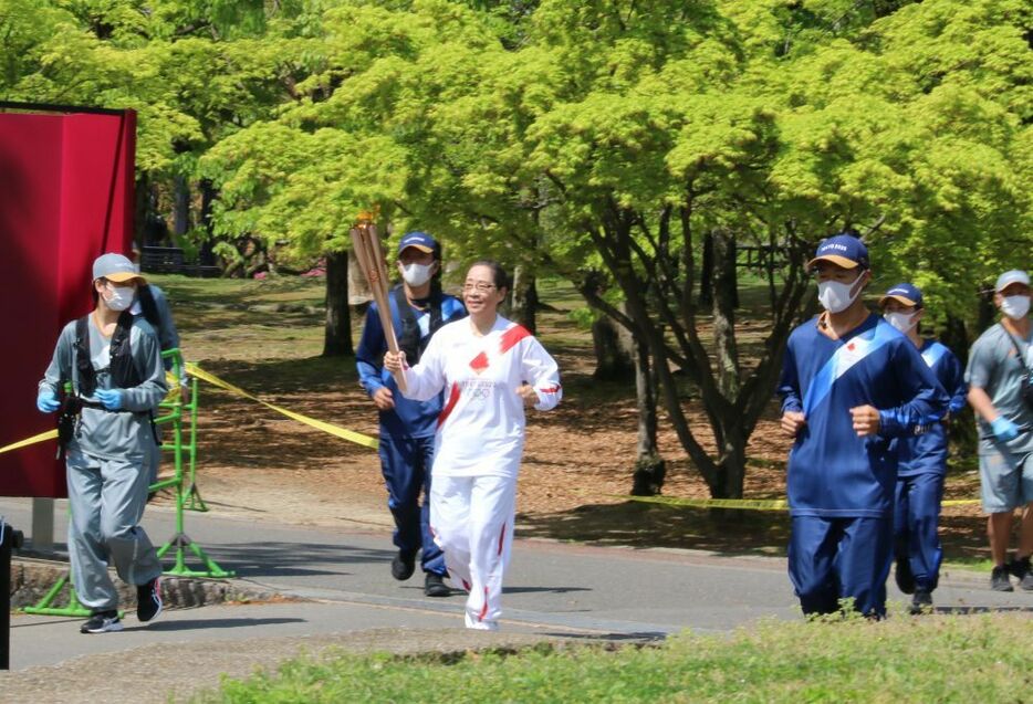 聖火ランナーと誘導するスタッフ