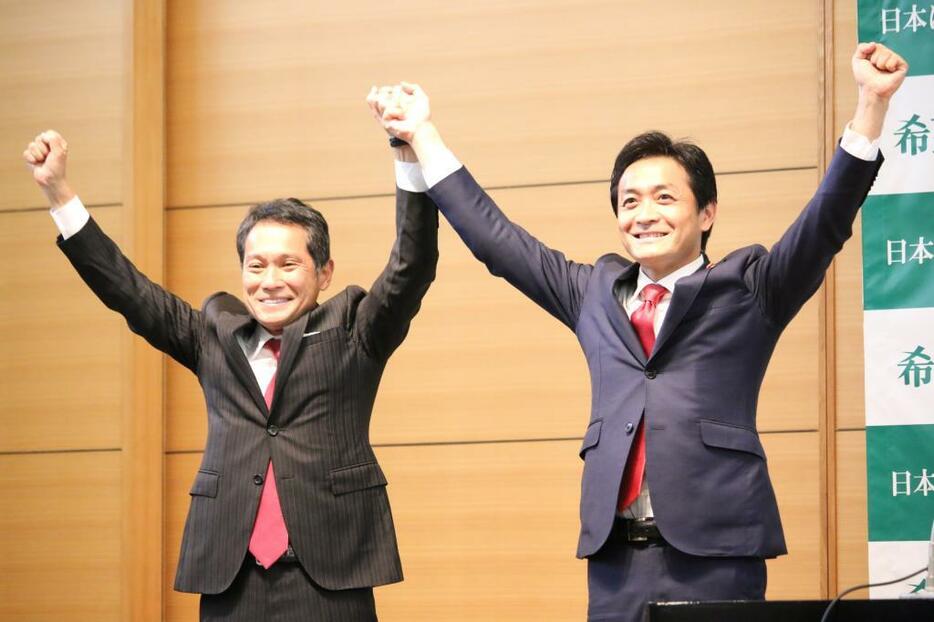 [写真]共同代表選の後、壇上で両腕を掲げる玉木共同代表（右）と大串氏