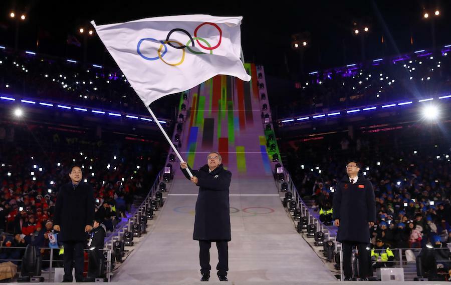 平昌五輪は閉幕した。大会は成功だったのか。五輪旗を持つIOC会長（写真・ロイター／アフロ）