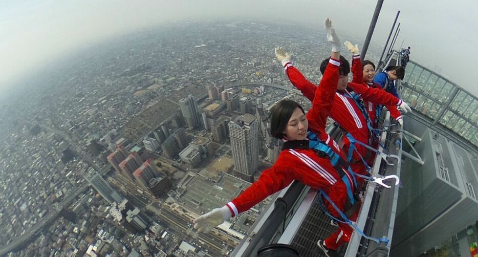 [写真]日本一の超高層ビル「あべのハルカス」にスリル満点のデッキが新設された。体験者は命綱をつけて背中を反るが思わず目をつぶってしまう。天球カメラで撮影＝28日午前11時40分ごろ、大阪市阿倍野区で（撮影：柳曽文隆）