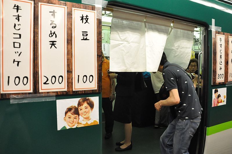 [写真]電車のドアにのれんとメニュー。お手ごろ価格で飲みやすい=22日午後6時すぎ、大阪市北区