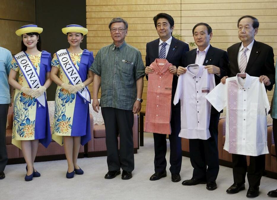 [写真]5月25日、首相官邸を訪れた翁長・沖縄知事（左から3人目）から「かりゆし」を贈られる安倍首相（同4人目）（ロイター/アフロ ）