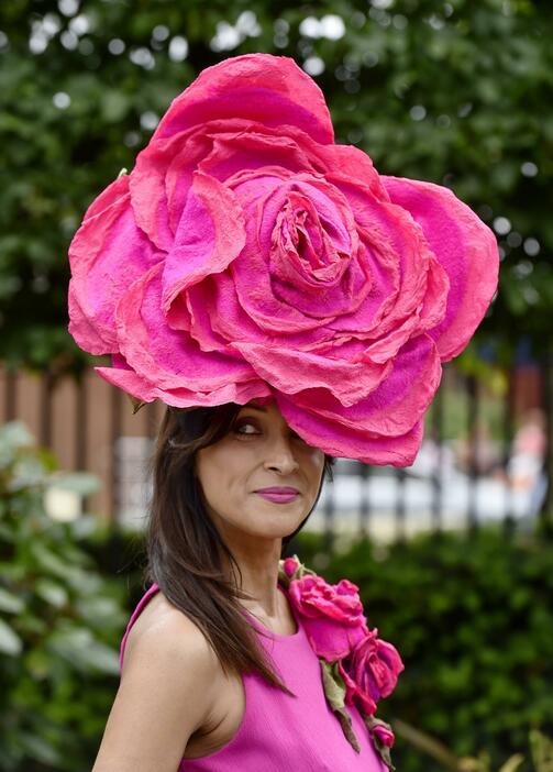 大きな花の帽子をかぶりポーズを決める女性＝2015年6月17日（写真：ロイター/アフロ）