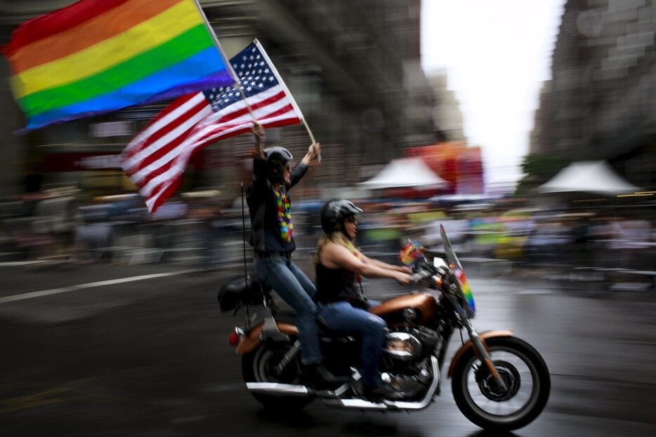 虹色の旗とアメリカ国旗がひるがえる＝2015年6月28日（写真：ロイター/アフロ）