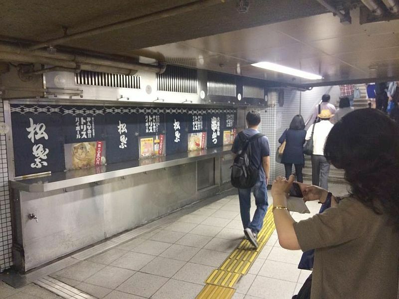 [写真]閉店状態の「松葉」の写真を撮る人が多い。中には並んで記念撮影する人もいた＝13日午後1時半ごろ、大阪市北区で