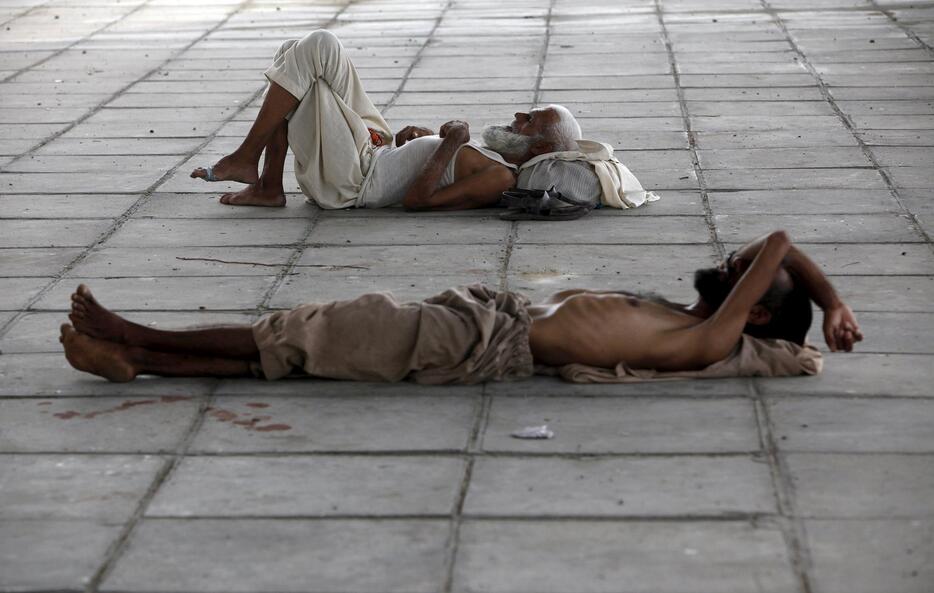 橋の下の日陰で眠る男性＝2015年6月22日（写真：ロイター/アフロ）