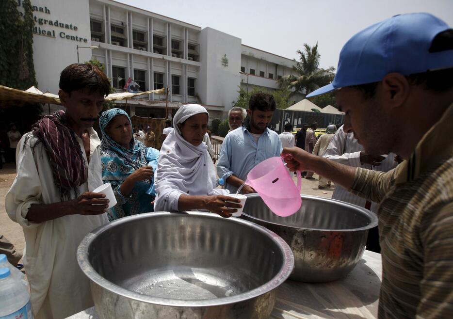 ボランティアから飲み水を受け取る人々＝2015年6月23日（写真：ロイター/アフロ）